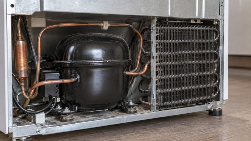 Close-up of a refrigerator's compressor and condenser coils